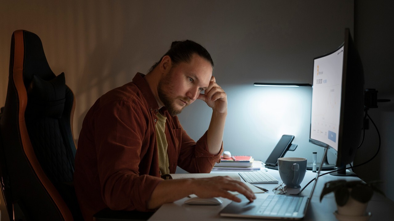 A cybersecurity analyst working late under heavy alert load.