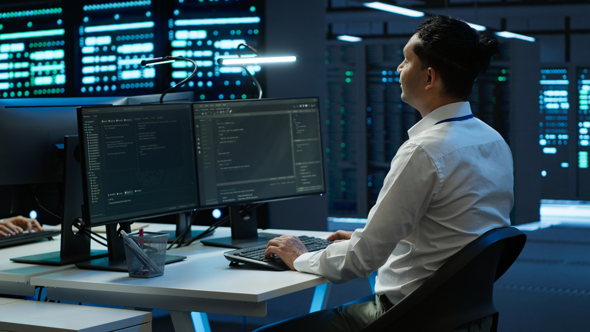 Cybersecurity experts working in a data center with multiple monitoring screens
