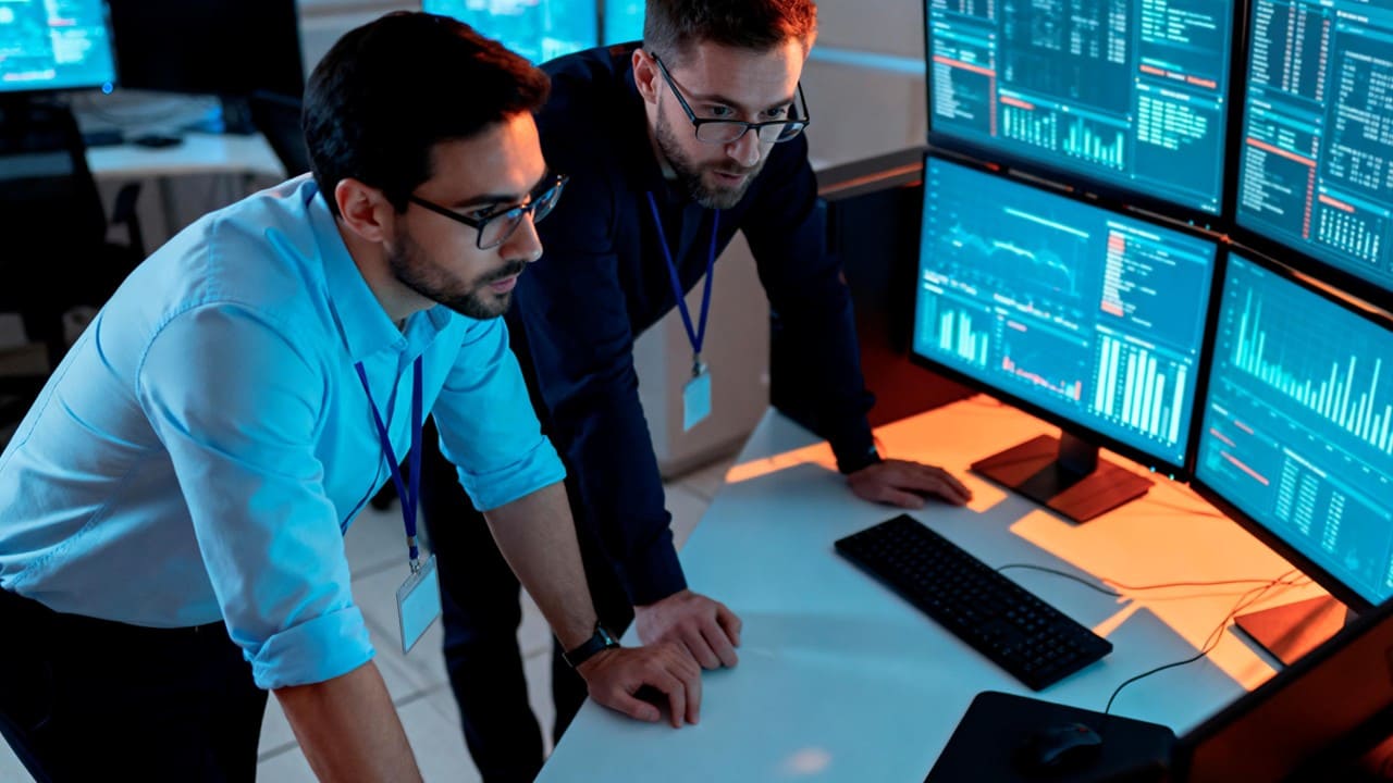 Hai chuyên gia nam trước màn hình máy tính