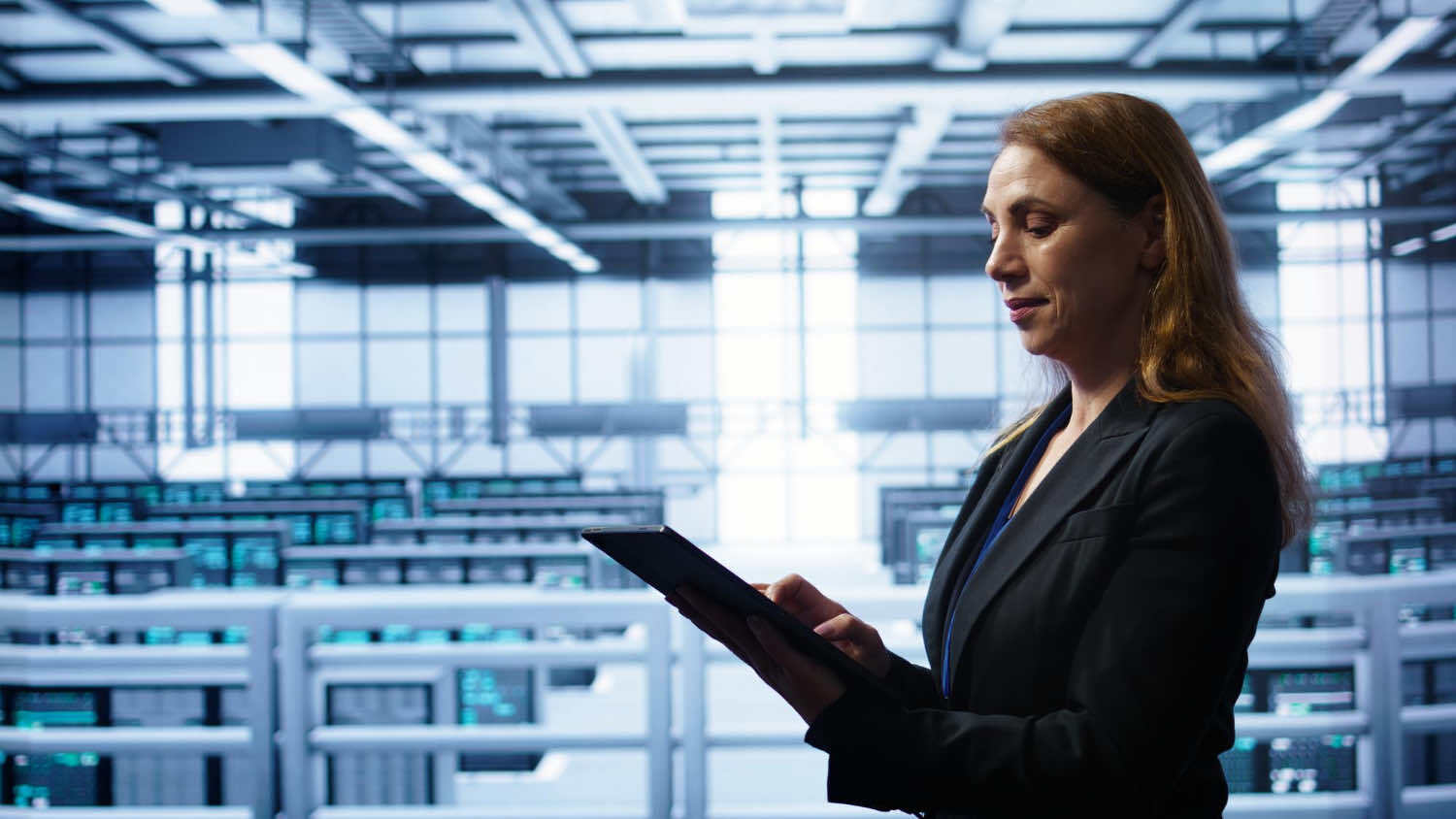 Nữ chuyên gia dùng máy tính bảng trong trung tâm dữ liệu hiện đại.