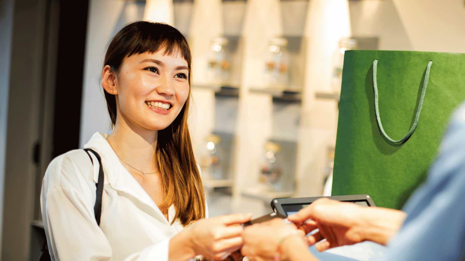 The customer completes their purchase with a smile, satisfied after a pleasant shopping experience.